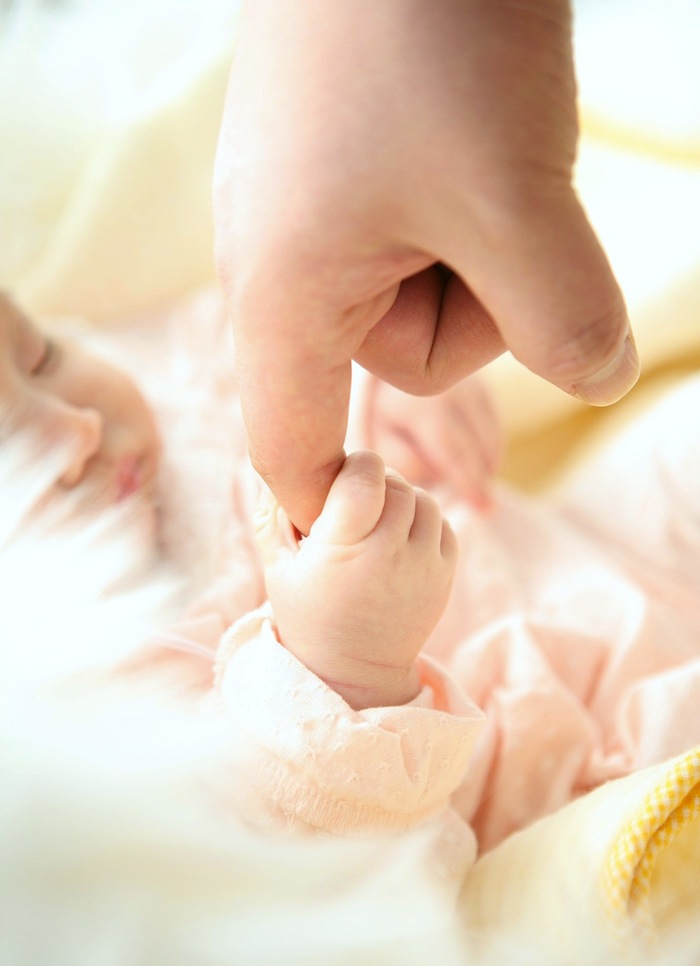 Baby holding finger